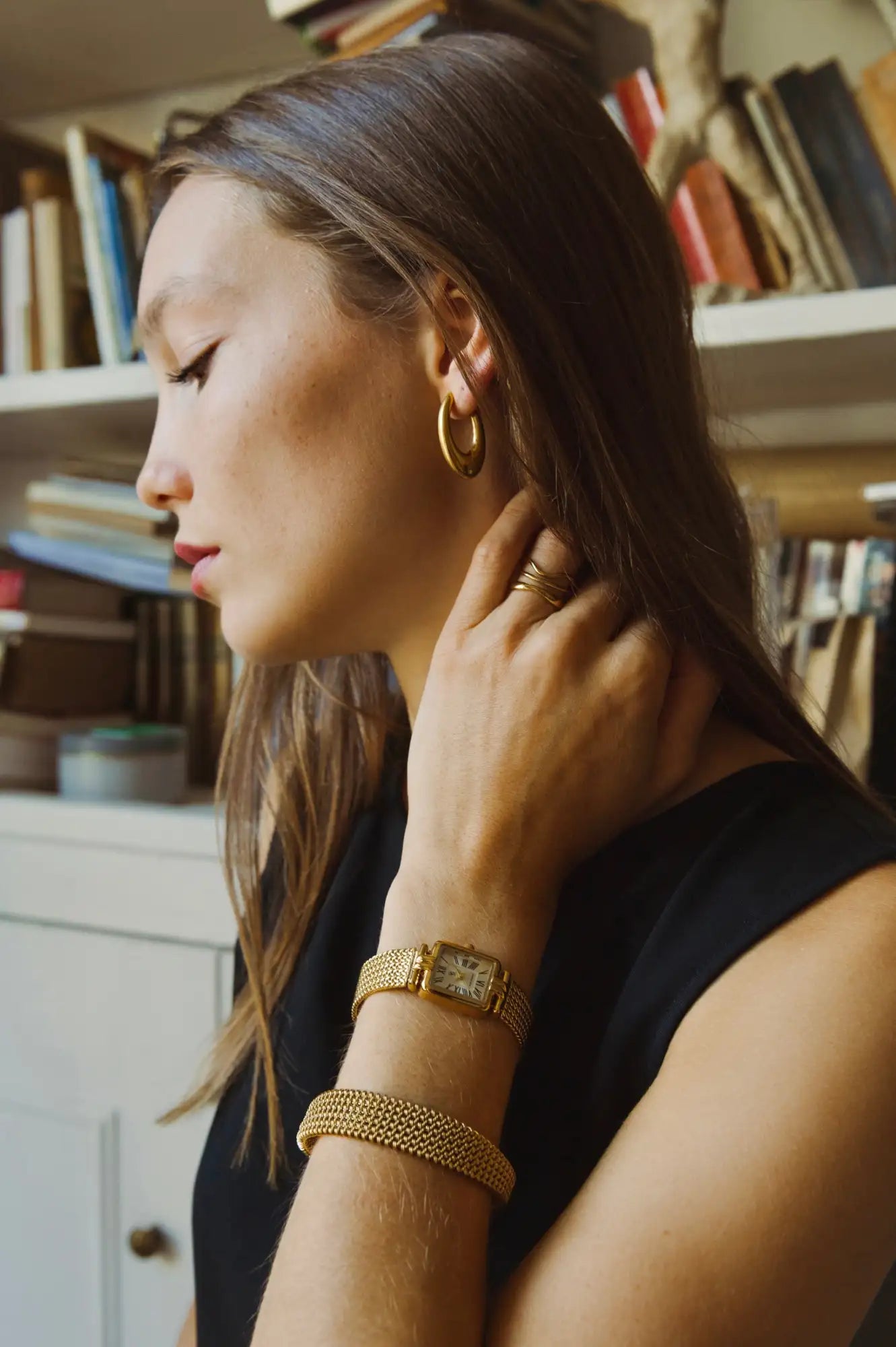 Bracelet en maille d'or avec une montre à cadran rectangulaire sur le poignet
