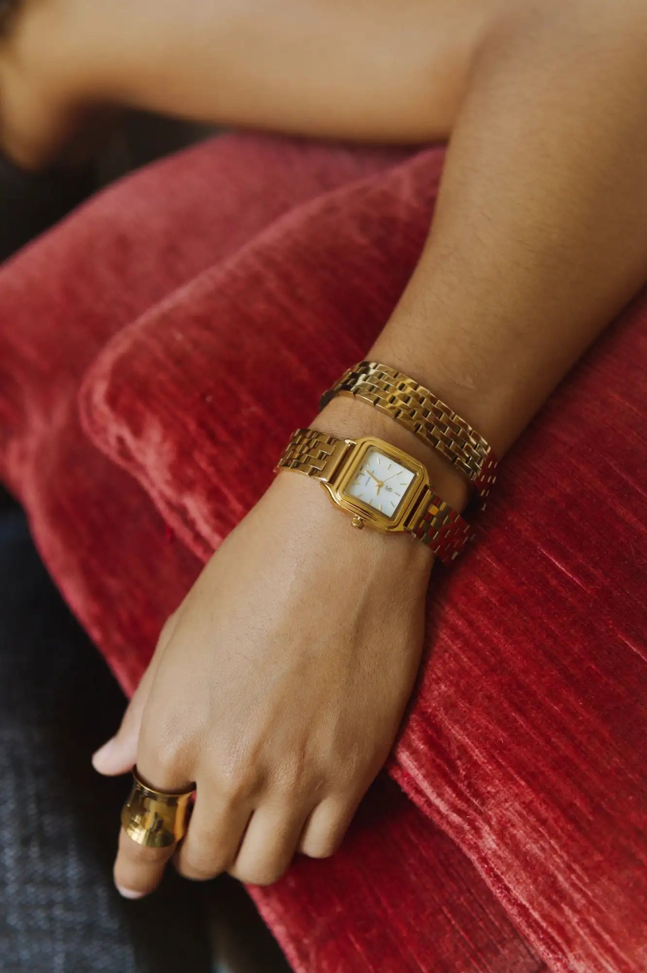 Montre rectangulaire aux tons dorés avec un bracelet en maille et un cadran blanc