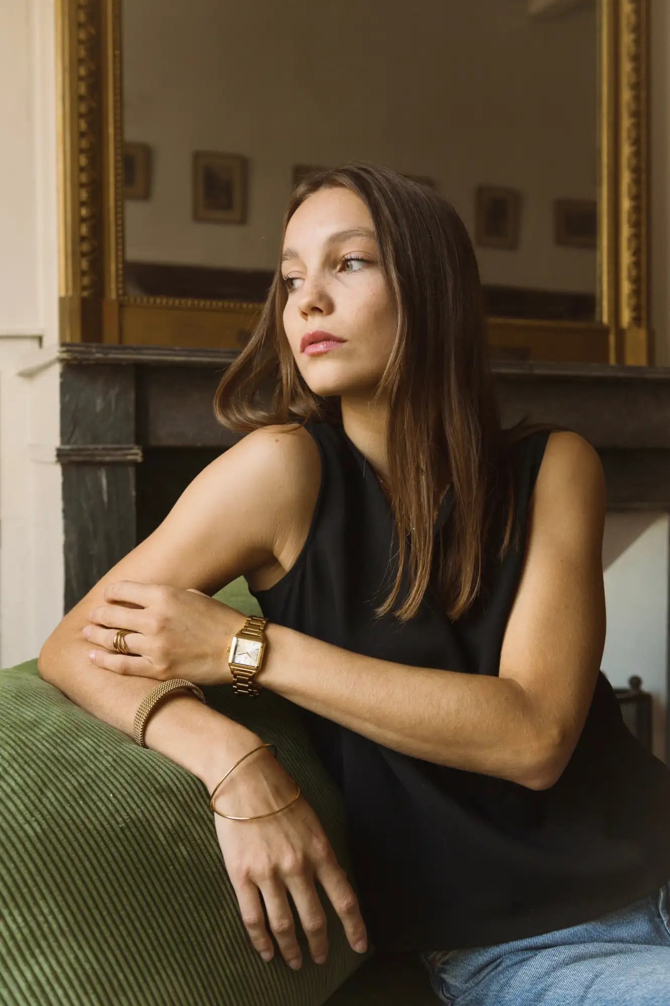 Montre rectangulaire aux tons dorés avec un design minimaliste et des marqueurs d'heures subtils.