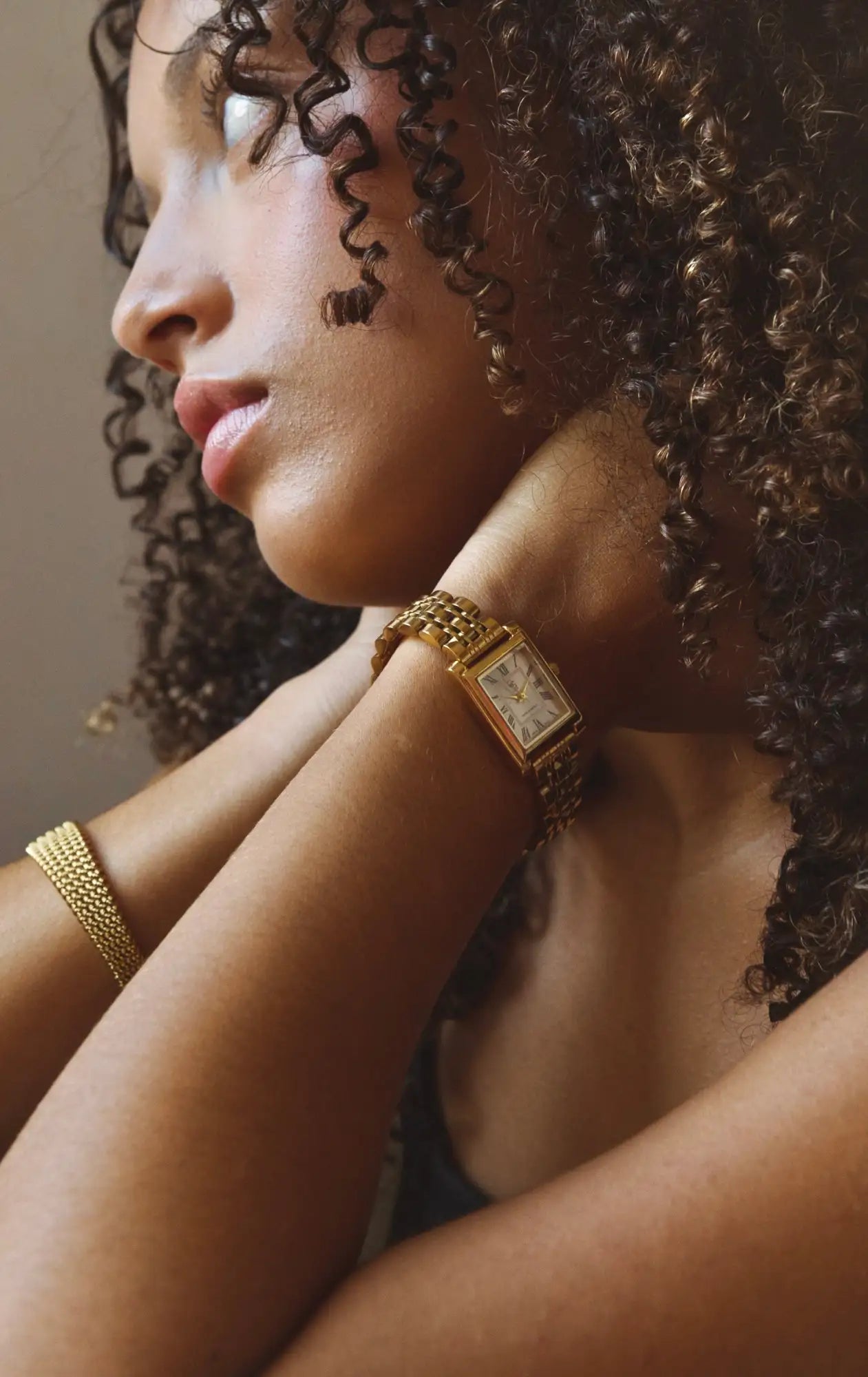 Montre rectangulaire en or avec un bracelet en maille et un cadran classique